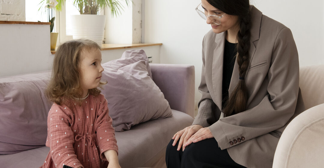 Criança em sessão terapêutica com profissional especializada, representando o cuidado na transição infantil com acompanhamento multidisciplinar e apoio emocional.